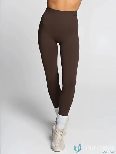 Brown leggings with white socks and beige sneakers.