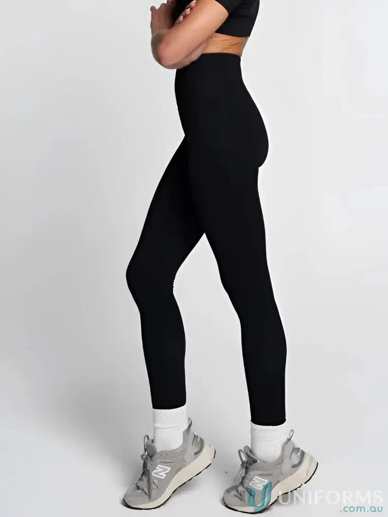 Black leggings with high waist and ankle-length design, made of stretchy fabric.