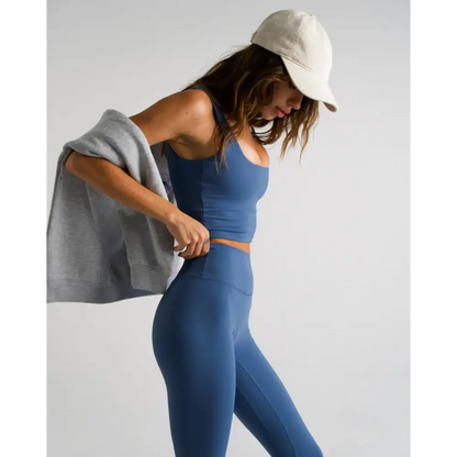 Blue athletic wear set with a gray sweater and beige baseball cap.