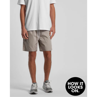 Man wearing beige shorts and gray sneakers.