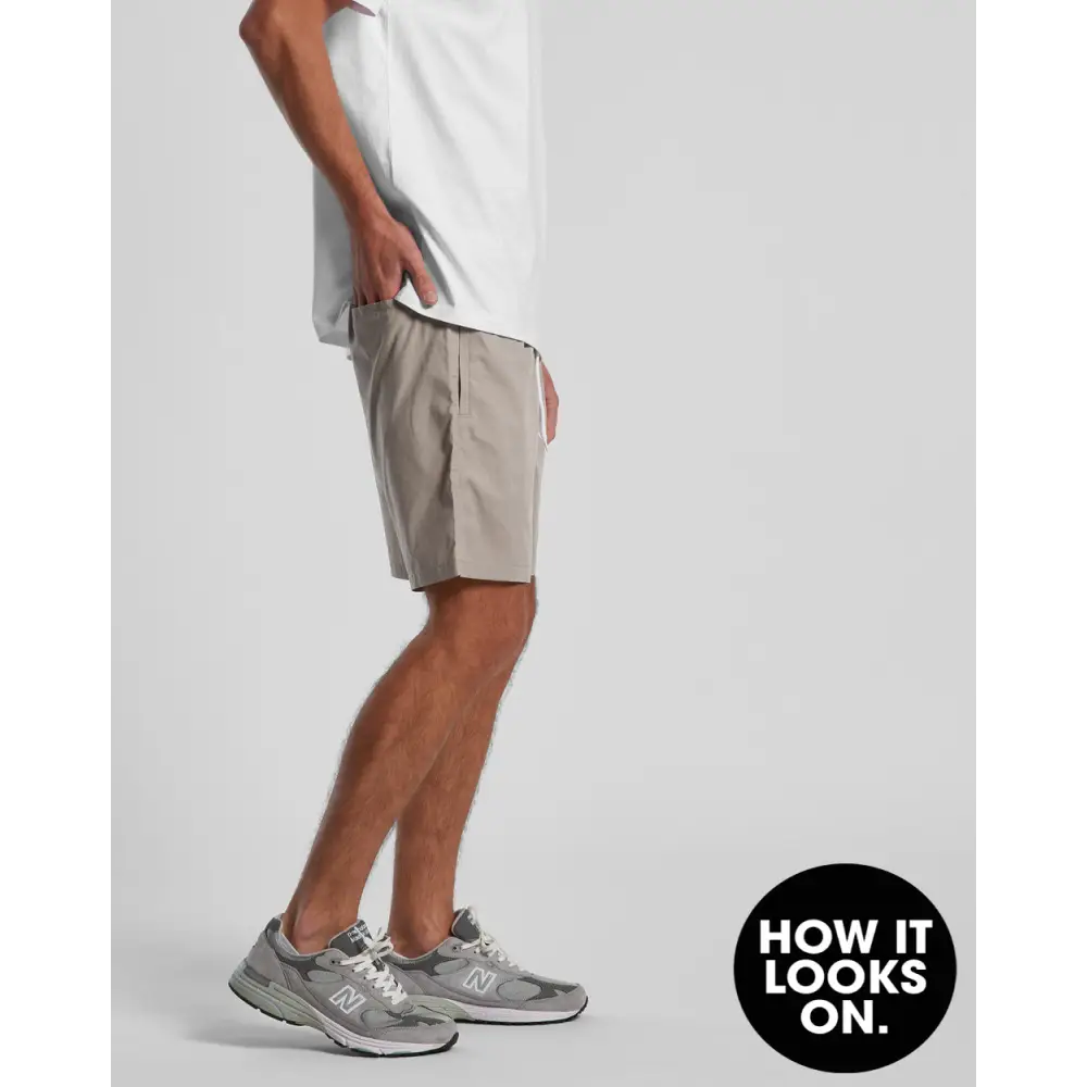 Man wearing gray shorts and sneakers.