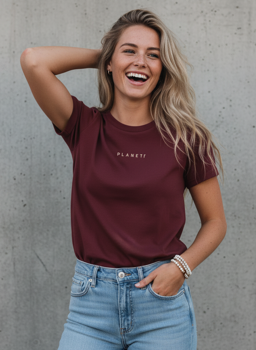 A woman wearing a maroon t-shirt and light blue jeans.
