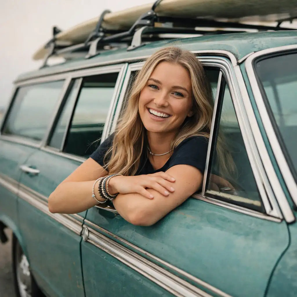 Teal vintage station wagon with surfboards mounted on the roof rack.