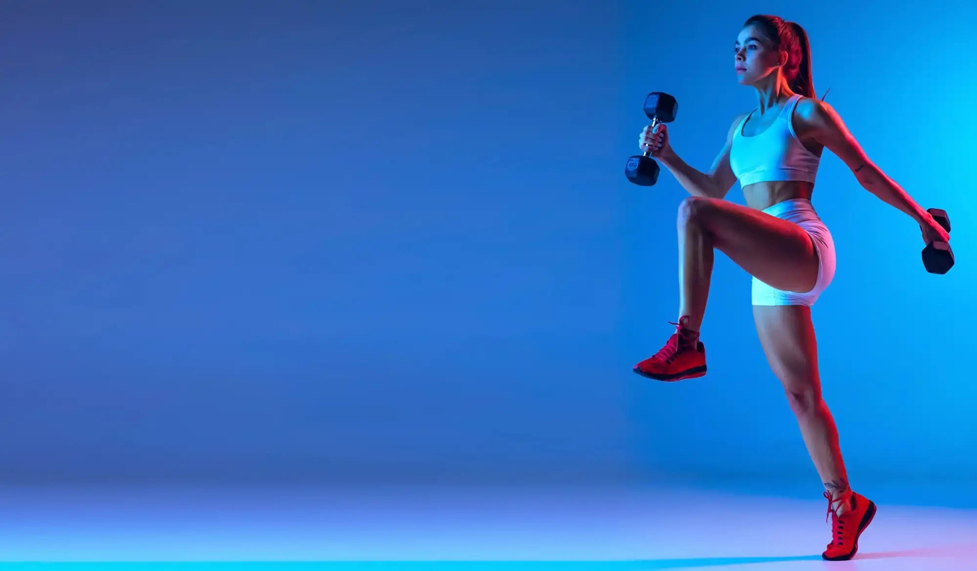 portrait-young-sportive-girl-training-with-dumbbells-isolated-blue-background-neon