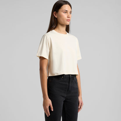 Cream-colored cropped t-shirt with puff sleeves and black pants.
