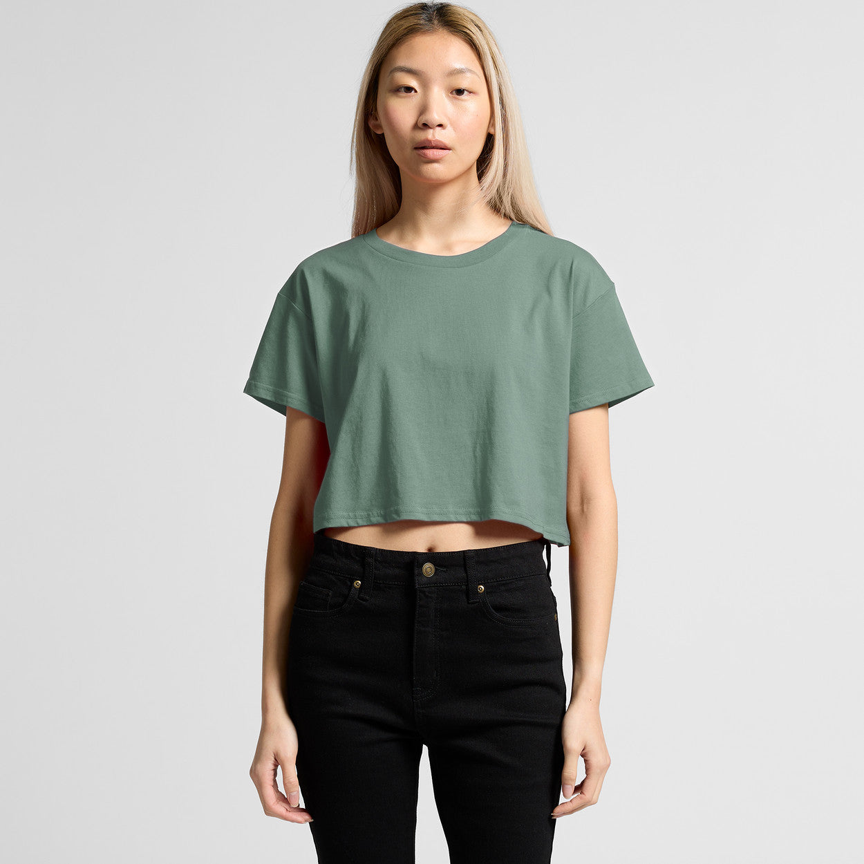 Green cropped t-shirt with short sleeves and black jeans.